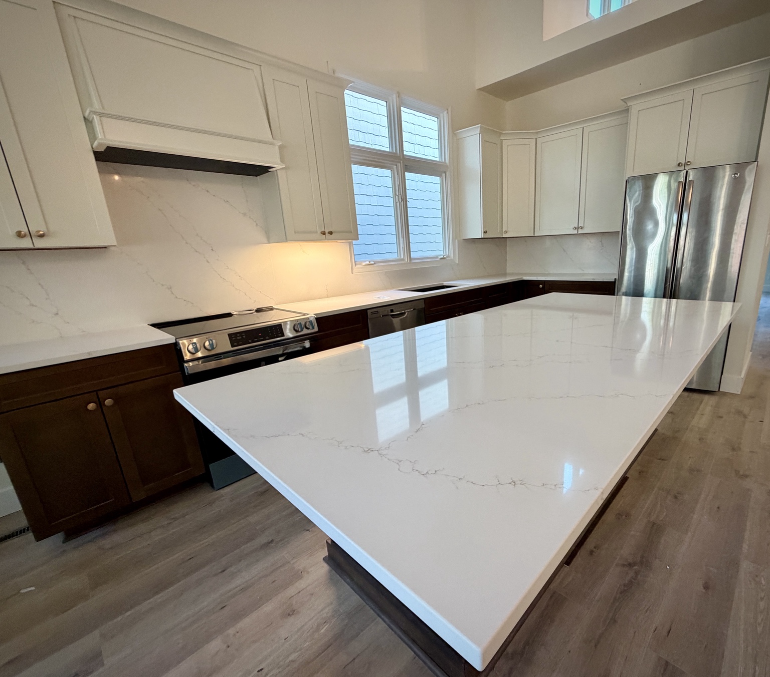 Bright white kitchen with a large stone island