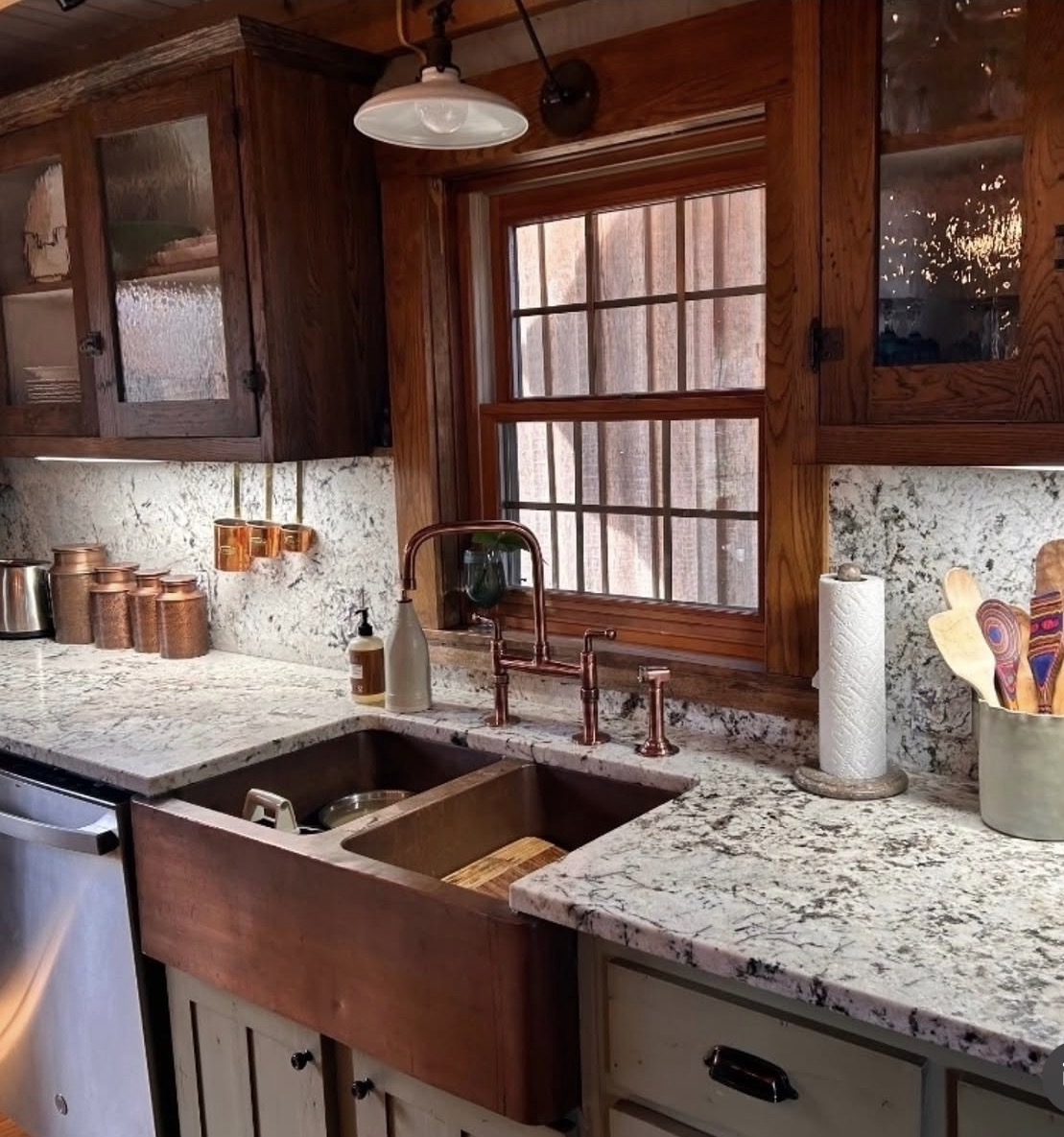 Rustic kitchen with a copper farmhouse sink and granite countertops