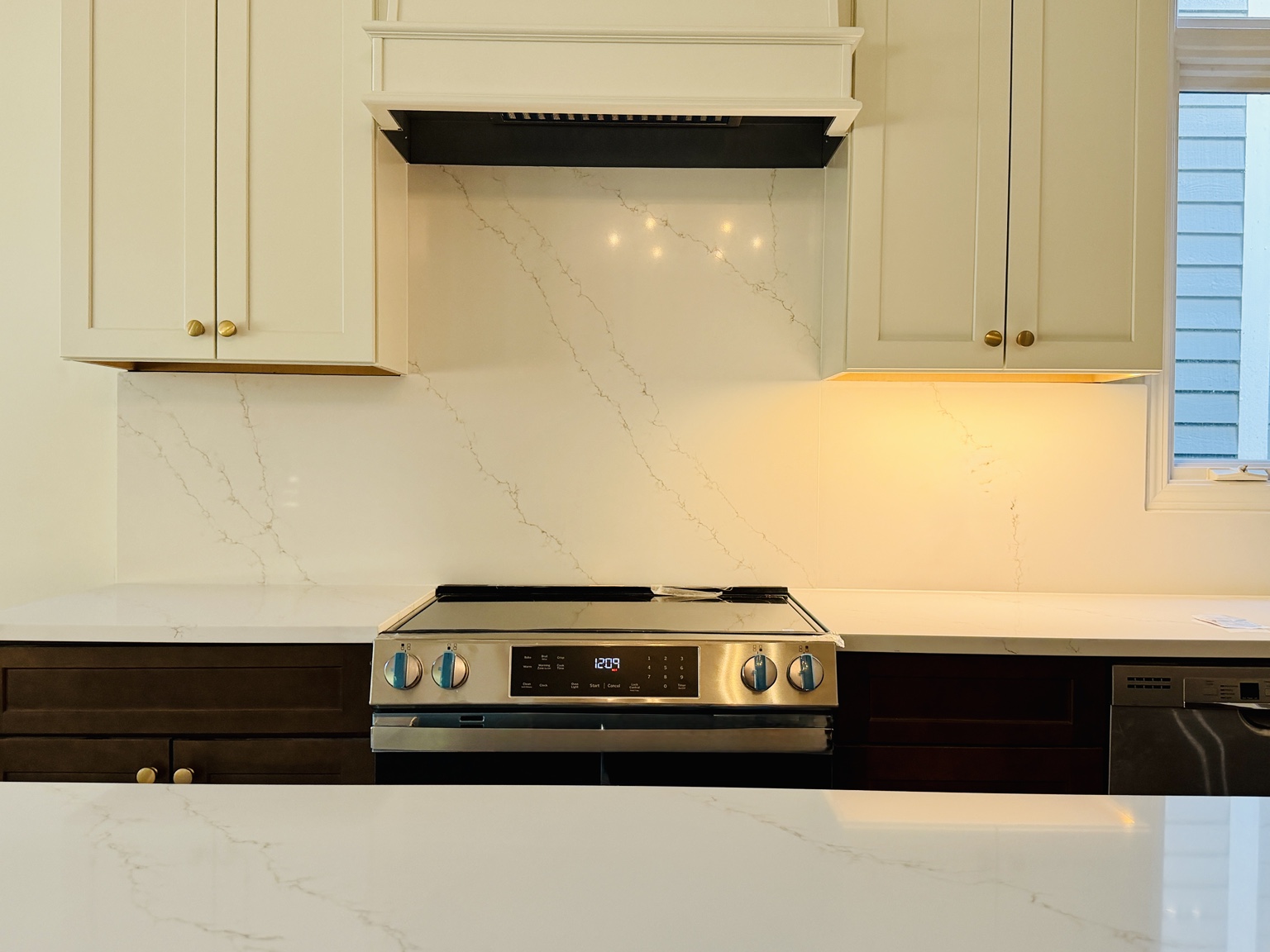Full-height white veined stone backsplash installation